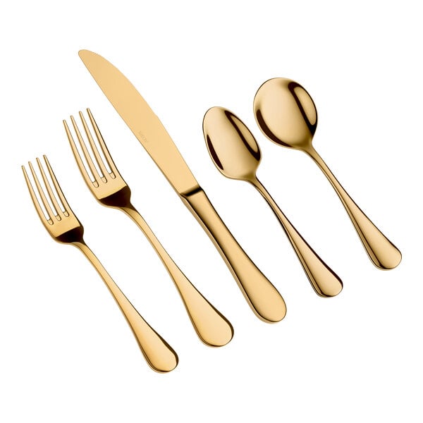 Five pieces of gold-colored flatware, including two forks, a knife, and two spoons, are arranged side by side on a white background.