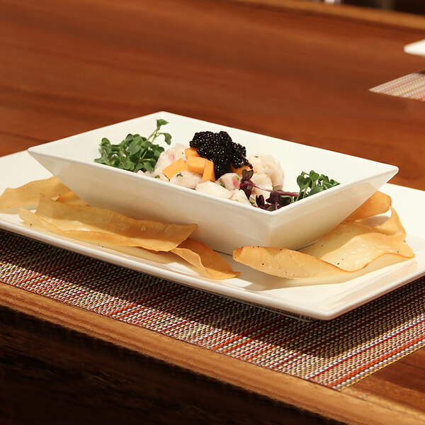 A white rectangular bowl filled with food on a table.