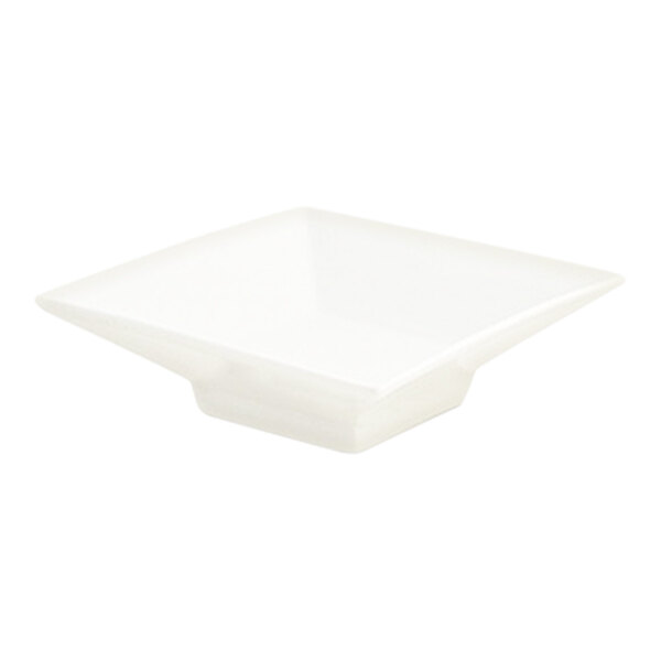 A small, square, white porcelain footed sauce dish.