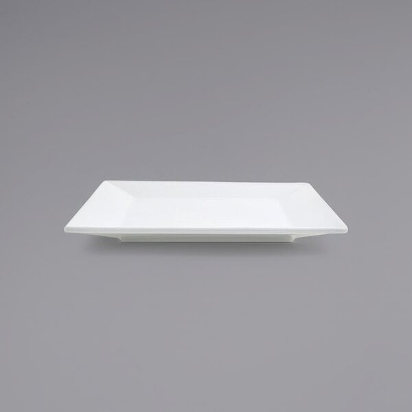 A Front of the House Kyoto bright white square porcelain plate on a gray surface.