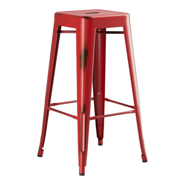 A Lancaster Table & Seating red metal backless barstool with legs.