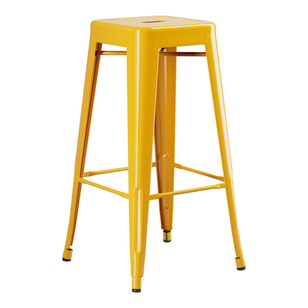 A Lancaster Table & Seating yellow metal backless barstool.