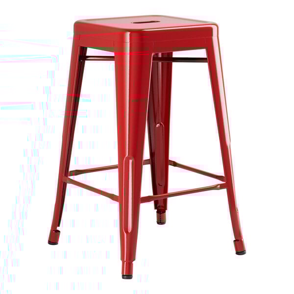 A red metal Lancaster Table & Seating backless counter height stool with legs.