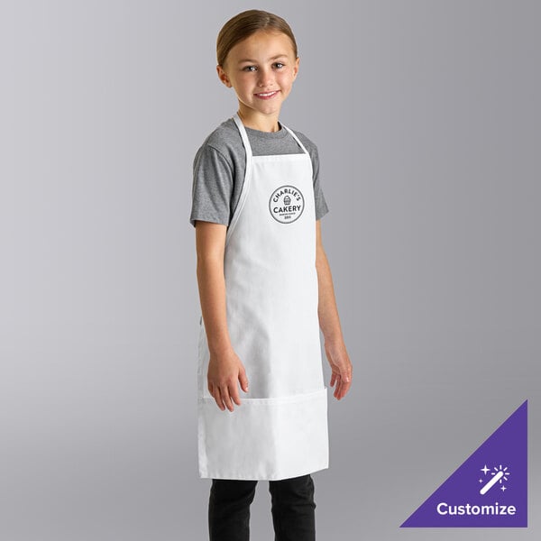 A young girl wearing a white Uncommon Chef youth bib apron with the logo.