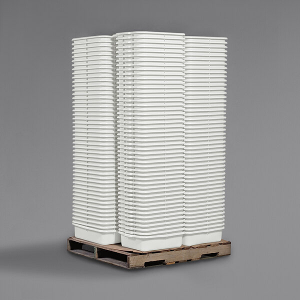 A stack of Tablecraft white high density polyethylene bus tubs.