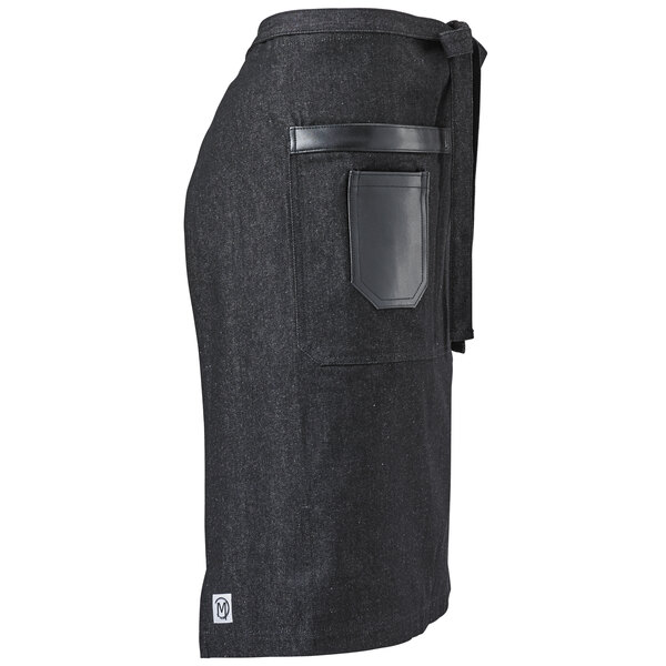 A black denim bistro apron with black leather details and pockets.