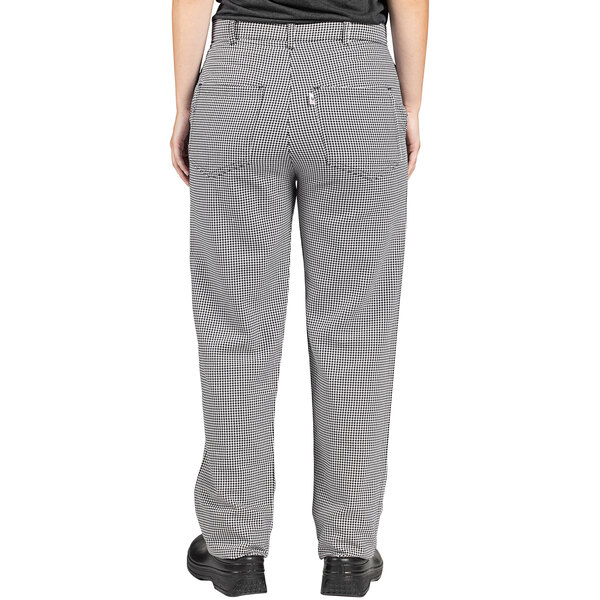 A person wearing Uncommon Chef houndstooth chef pants with a customizable straight leg.