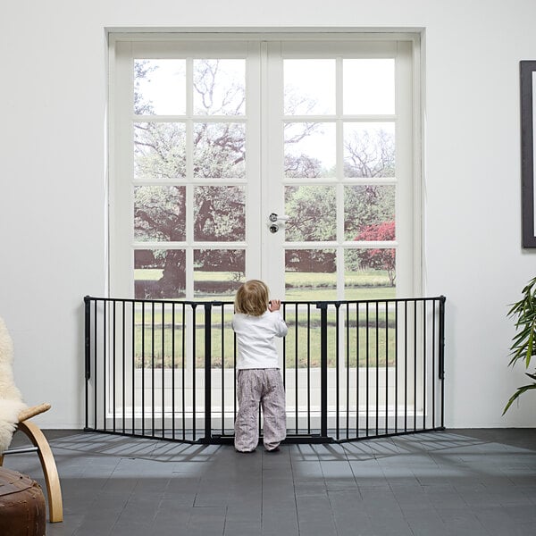 A child standing behind a black safety gate
