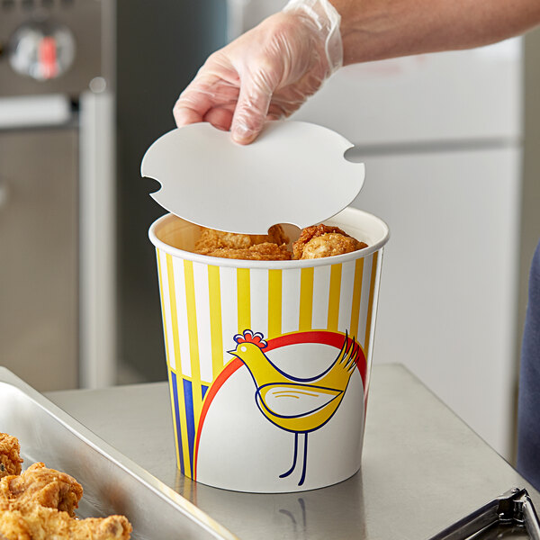 A hand in a plastic glove opening a Choice chicken bucket.
