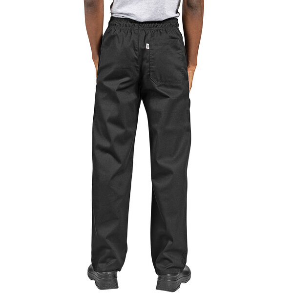 The legs of a person wearing black Uncommon Chef cargo pants.