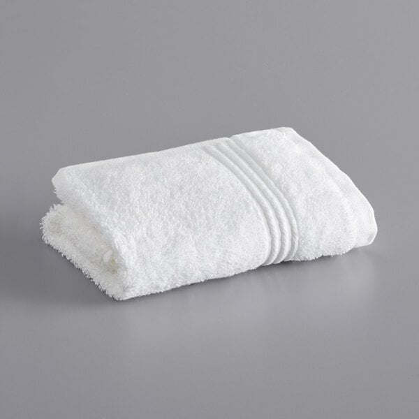 A white Lavex Luxury washcloth on a gray surface.
