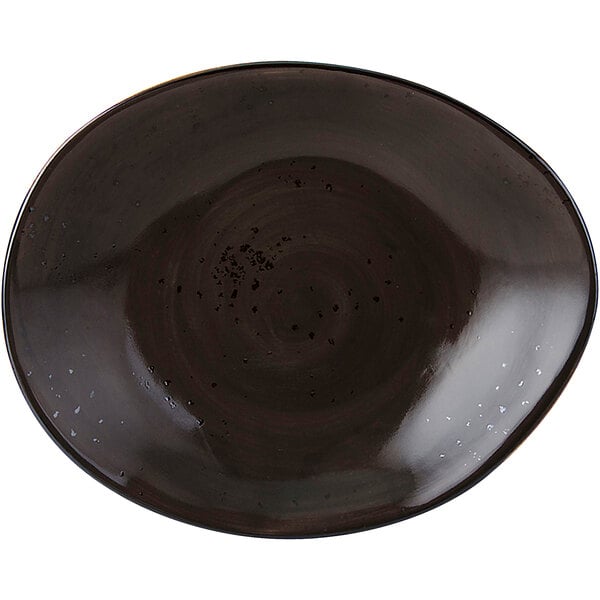 A black Tuxton China ellipse plate with a speckled surface.