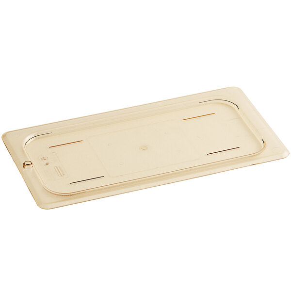 A Cambro 1/3 size plastic food pan lid in amber on a plastic tray.