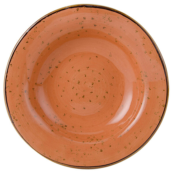 A close-up of a Tuxton TuxTrendz Geode Coral soup bowl with a speckled orange design.