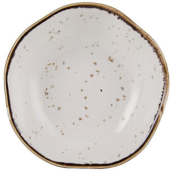 A white Tuxton China fruit cup with brown specks on it.