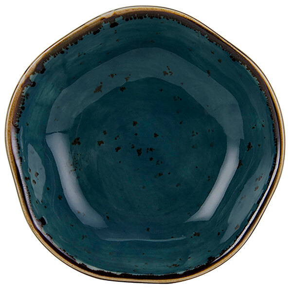 A blue bowl with brown specks on a white surface.