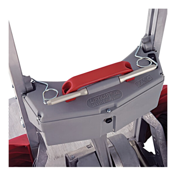 A close up of a red handle on a gray and silver Magliner lifter with a white background.