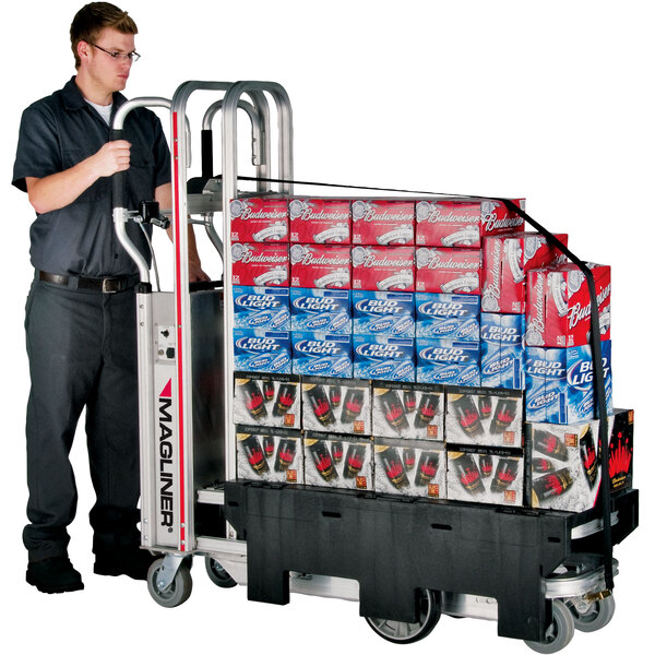 A man using a Magliner hand truck to move a stack of red boxes.