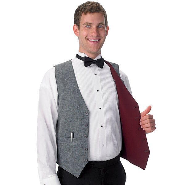 A man wearing a Henry Segal reversible server vest in burgundy and gray with a bow tie.