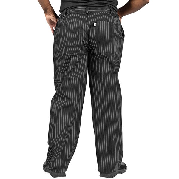 A person wearing Uncommon Chef pinstripe pants with white stripes on a black background.