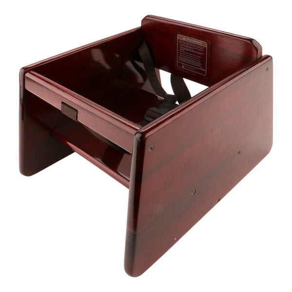 A mahogany wooden booster seat with T-strap.