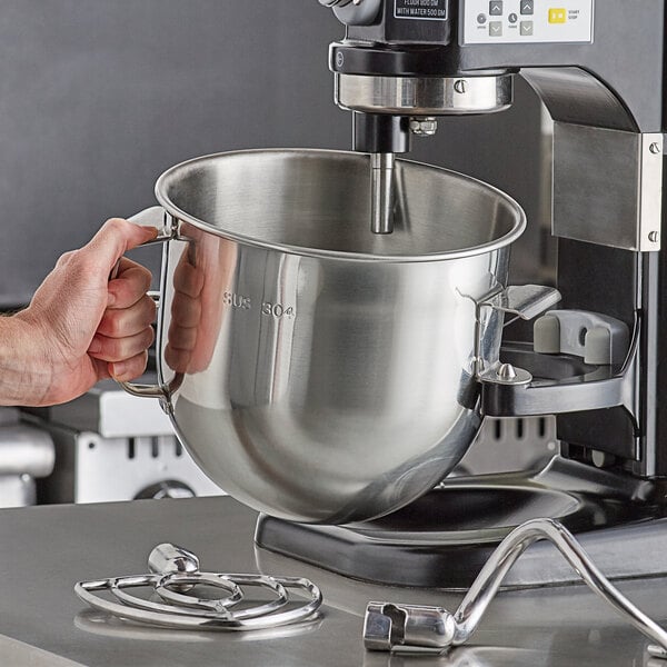 A person holding an Avantco 8 qt. metal mixer bowl.