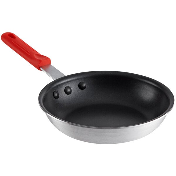 A Choice aluminum non-stick frying pan with a red silicone handle.