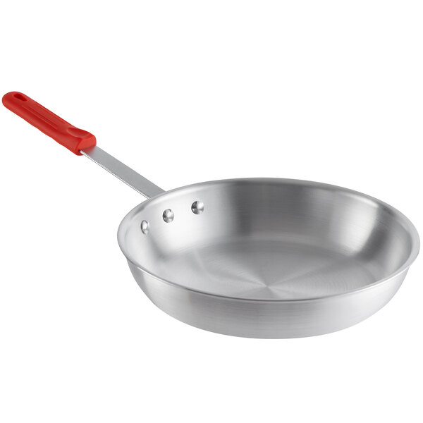 A Choice aluminum frying pan with a red silicone handle.