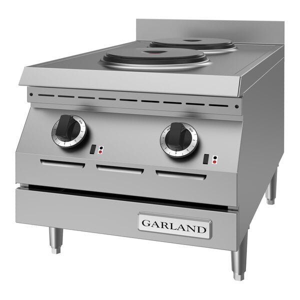 A stainless steel countertop hot plate with two solid electric burners and control knobs, designed for commercial kitchen use.
