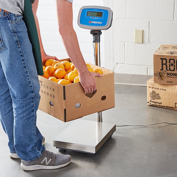 receiving scale measuring the weight of a box of oranges