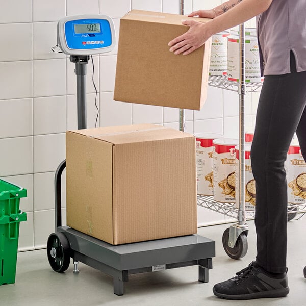 A person weighing a white box on an AvaWeigh digital receiving scale.