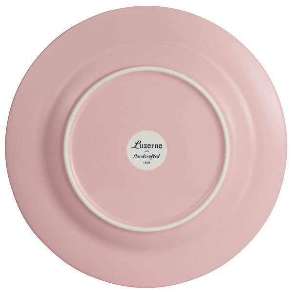 A pink porcelain plate with a white rim.