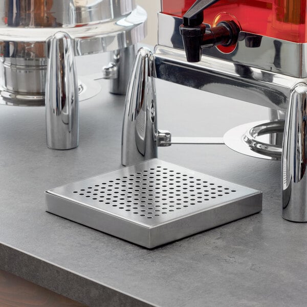 An American Metalcraft stainless steel drip tray on a counter next to a coffee machine.