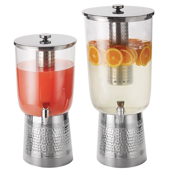 a couple of juice dispensers with oranges
