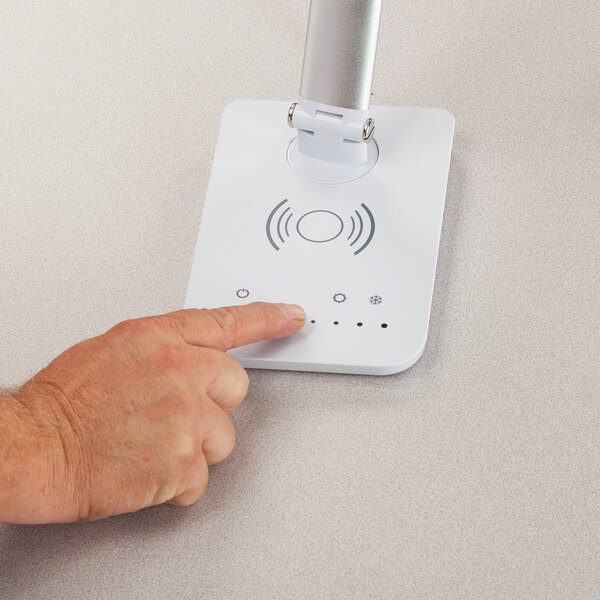 A white LED desk lamp with a wireless charging pad, multi-pivot adjustable arm, and touch controls.