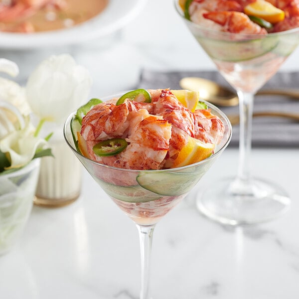 A martini glass filled with shrimp cocktail.