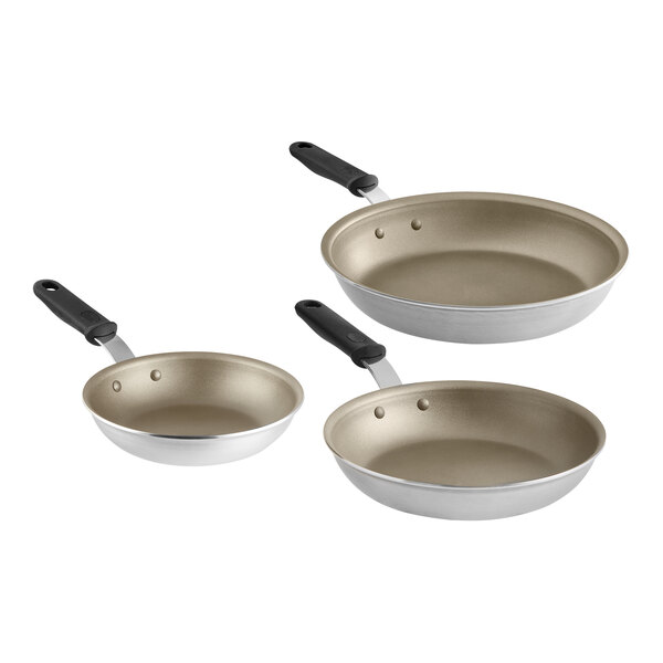 Three Vollrath Wear-Ever aluminum frying pans with black silicone handles.
