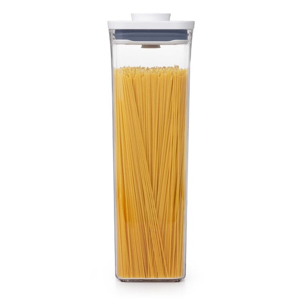 An OXO Good Grips square food storage container with spaghetti inside and a white lid.
