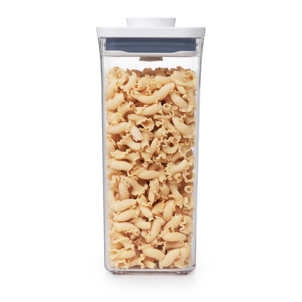 A close-up of a OXO Good Grips clear square plastic food storage container with pasta inside.