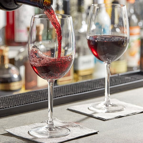 An Arcoroc Romeo wine glass filled with red wine on a table.