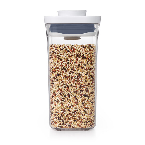 An OXO clear plastic food storage container with a white lid containing grains.