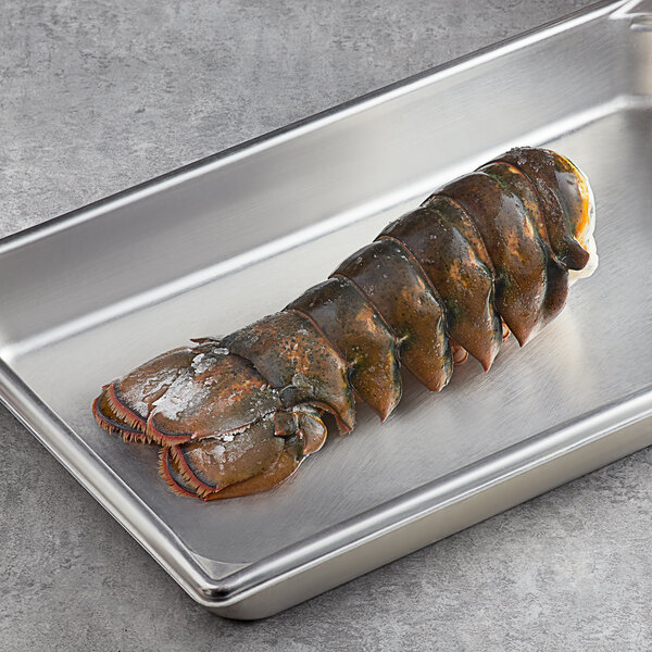A Boston Lobster Company 10 lb. case of lobster tails on a metal tray.