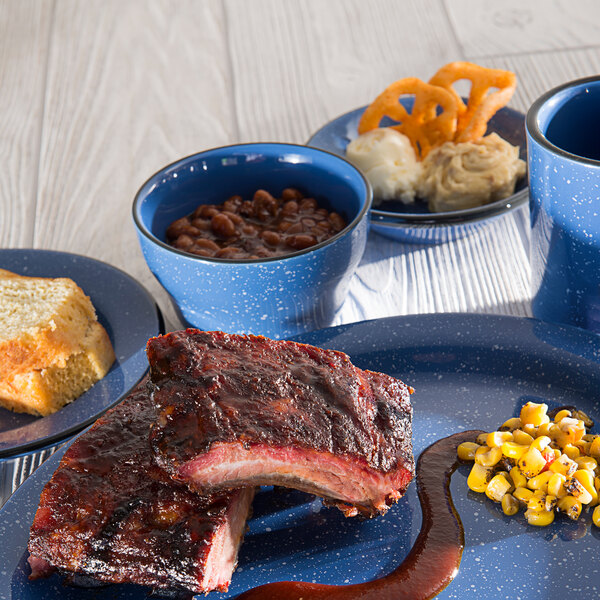 A plate of ribs, corn, and beans on a blue bowl.