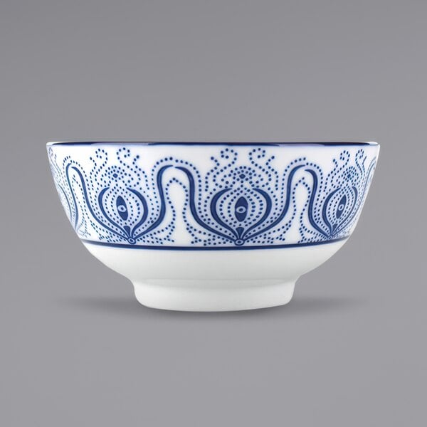 A white bowl with blue painted paisley designs.