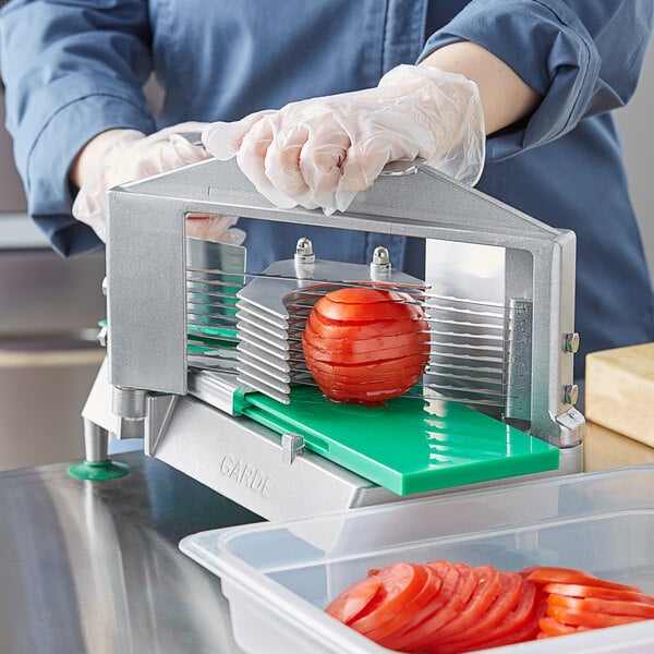 a tomato being sliced on a machine