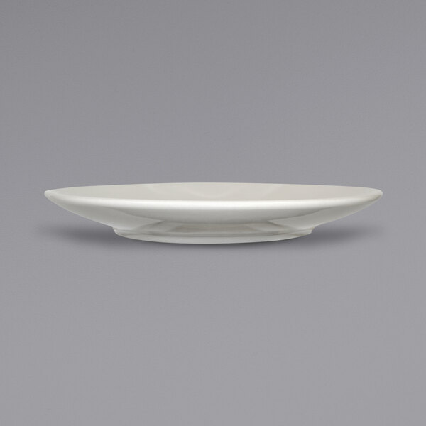 A white International Tableware Roma cappuccino saucer with a curved edge.