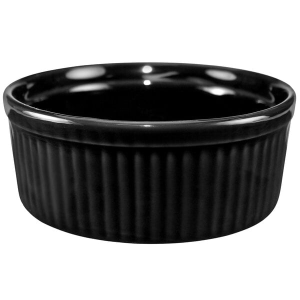 A black fluted stoneware ramekin with a rim.