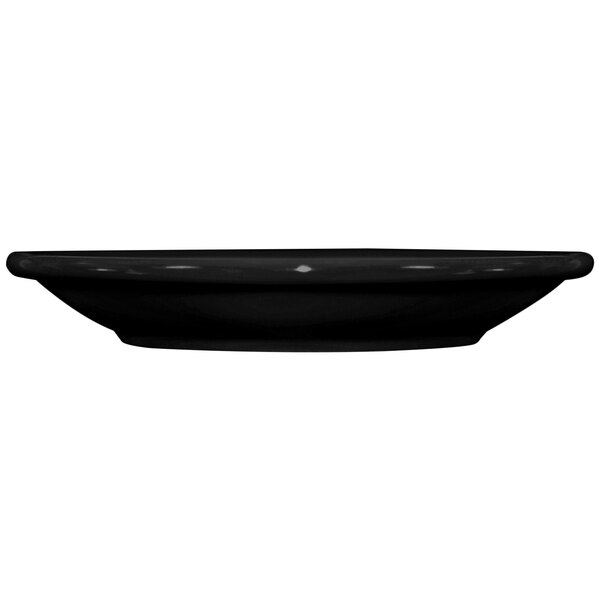 A black saucer with a white spot on a black surface.