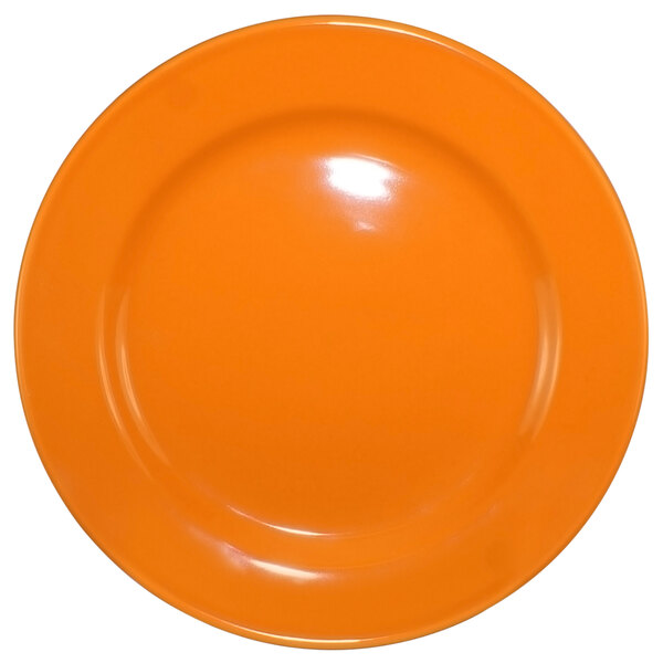 An orange International Tableware stoneware plate with a wide rim and rolled edge.