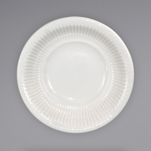 An International Tableware ivory stoneware bowl with an embossed pattern and ribbed edge.